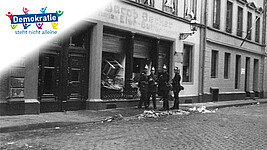 Polizisten vor einem zerstörten jüdischen Geschäft 1938